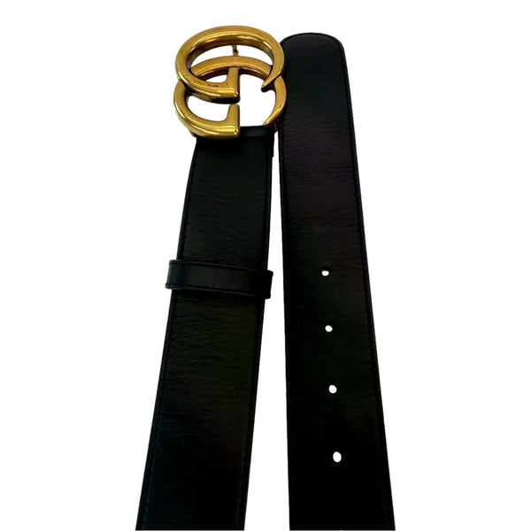 Gucci GG Marmont black leather belt laid lengthwise, showing the Double G buckle and adjustment holes